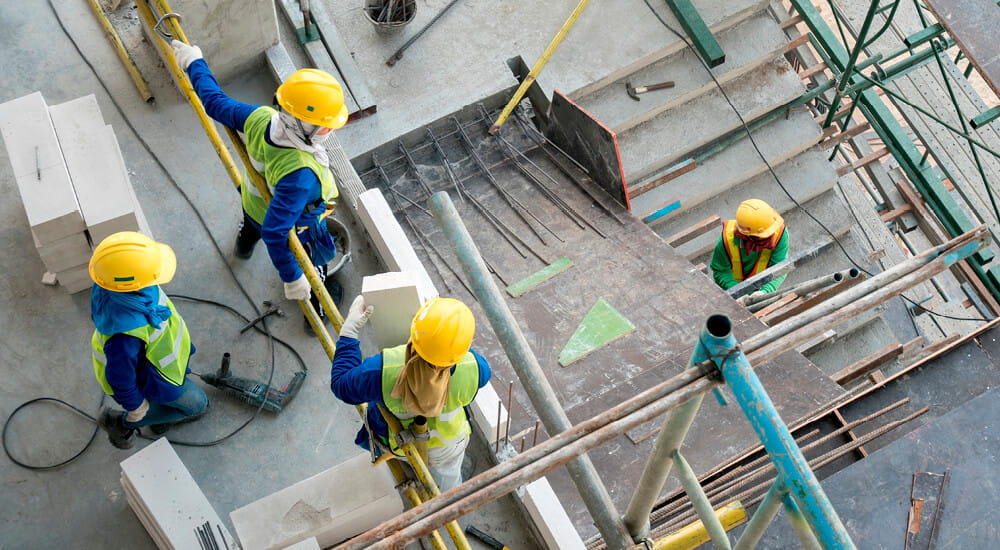 Construction workers at a construction site viewed from above.